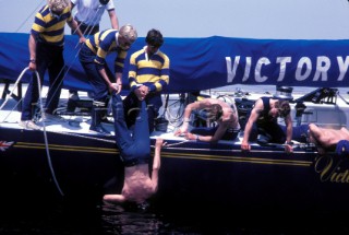 Crew member lowered in to the water by his crewmates to inspect the hull