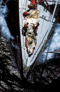 Aerial view of crew preparing sail on foredeck of racing yacht