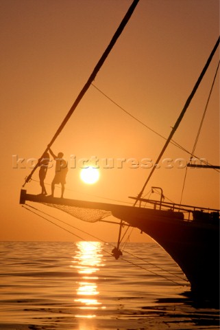 Romantic couple on bowsprit of classic yacht