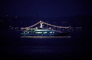 Cruising superyacht at anchor illuminated at night in a quiet anchorage mooring