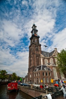 A bird flies by a church tower in Amsterdam, Netherlands.