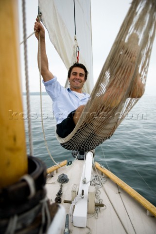 Man smiling in a hammock while cruising on sailboat Casco Bay Maine New England releasecode rausher 
