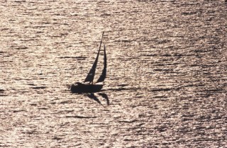 Silouette of cruising yacht in sunset on sea