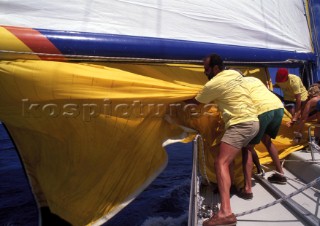 Crew bringing spinnaker onboard