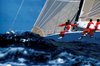 Sailors on the side on a racing yacht in rough seas