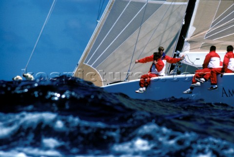 Sailors on the side on a racing yacht in rough seas