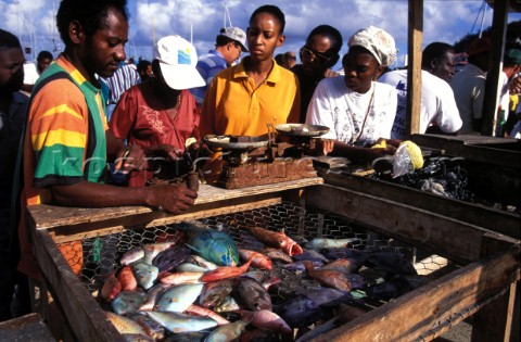 People gathered round a fish stall at a market in St Martin Caribbean