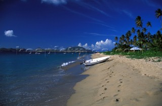 Dinghy with outboard engine on sandy beach, Nevis, Caribbean