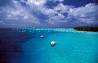 Two cruising yachts anchored in the shallow waters of Tahiti - Polynesia