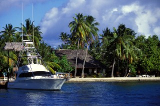 Games fishing boat moored off sandy beach