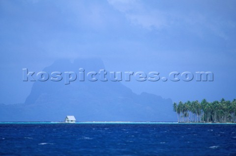 Hut on stilts in shallow water French Polynesia