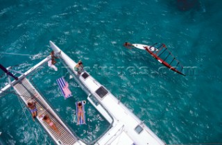 Guests sunbathing on an anchored catamaran