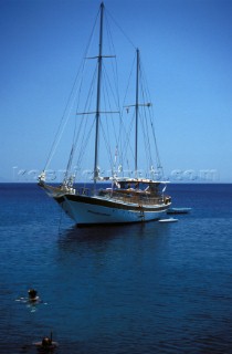 Two people snorkelling off anchored classic sailing yacht