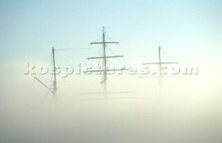 Masts and rigging of a tall ship covered by mist