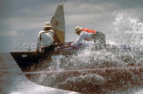 Two crew change the foresail on the bow of IACC yacht France 2