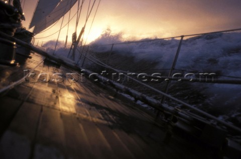 View along the side deck of a yacht under way at sunset