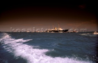 Royal yacht Britannia at anchor in Cowes Roads amongst smaller yachts with stormy sky