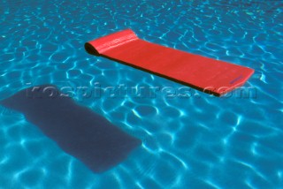 Lilo casts shadow floating on surface of swimming pool