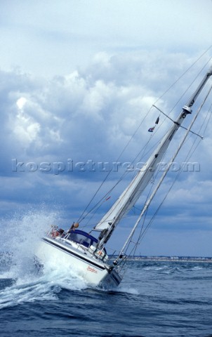 Cruising yacht rolling over wave UK