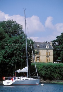 Sunsail - Brittany Coast Cruising European  Cruising yacht moored to a buoy by an old farmhouse on the Brittany coast, France