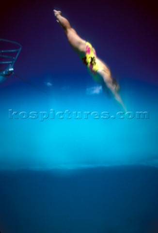 Girl diving into clear water shot from the surface