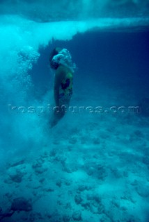 Girl diving into clear water shot from the surface