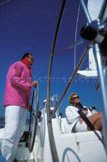 Man helming yacht with female passenger