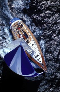 Aerial view of cruising yacht sailing down wind under spinnaker