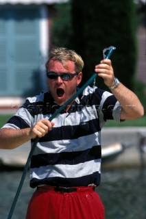 Fully clothed man soaked by hose pipe