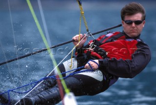 Dinghy sailor hiking out on a trapeze