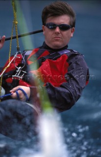 Dinghy sailor hiking out on a trapeze