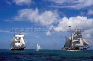 Square rigger tall ships sailing under blue skies