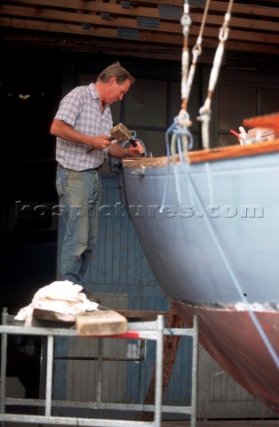 A Boat Builder carefully restores a classic sailing yacht