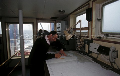 Salvage tug chart room Officer plotting ships course on a chart