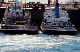 Two tugs manoevre an oil tanker