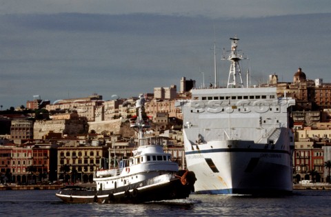 A tug move into position to manoeuvre a commercial ship