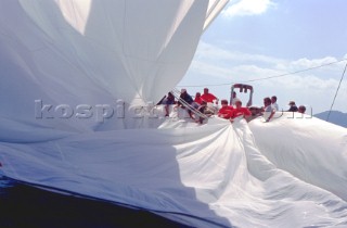 Crew of classic yacht strain to pull the huge spinnaker on board while racing