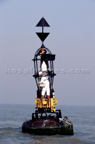 Man repairing an easterly Cardinal Buoy