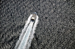 A ferry speeding over flat sea