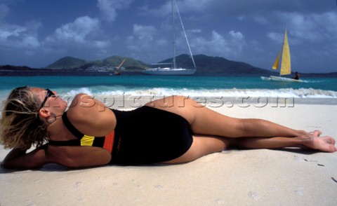 Woman lying on beach looking out to sea