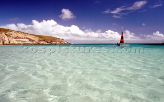 Sailing dinghy in shallow waters off sandy beach, Australia