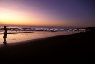 Silhouette of woman on beach at sunset