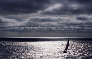 Single yacht at sea under dramatic sky