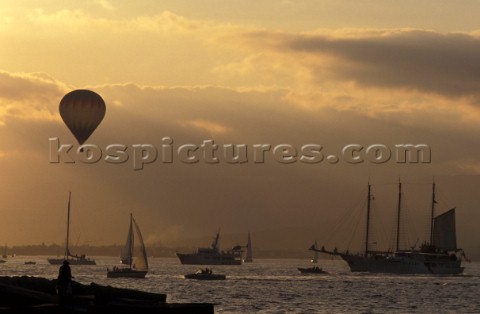 Hot air balloon flying over the harbour of Saint Tropez France at sunset 