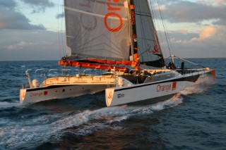 Maxi catamaran Orange skippered by Bruno Peyron crossing the startline of the Jules Verne