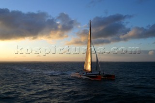 Maxi catamaran Orange skippered by Bruno Peyron crossing the startline of the Jules Verne