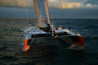 Maxi catamaran Orange skippered by Bruno Peyron crossing the startline of the Jules Verne