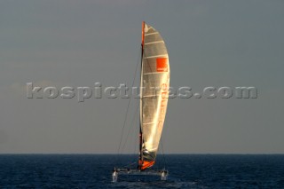 Maxi catamaran Orange skippered by Bruno Peyron crossing the startline of the Jules Verne