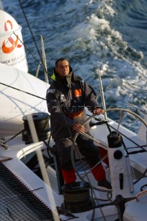 Maxi catamaran Orange skippered by Bruno Peyron crossing the startline of the Jules Verne