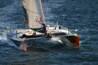 Maxi catamaran Orange skippered by Bruno Peyron crossing the startline of the Jules Verne